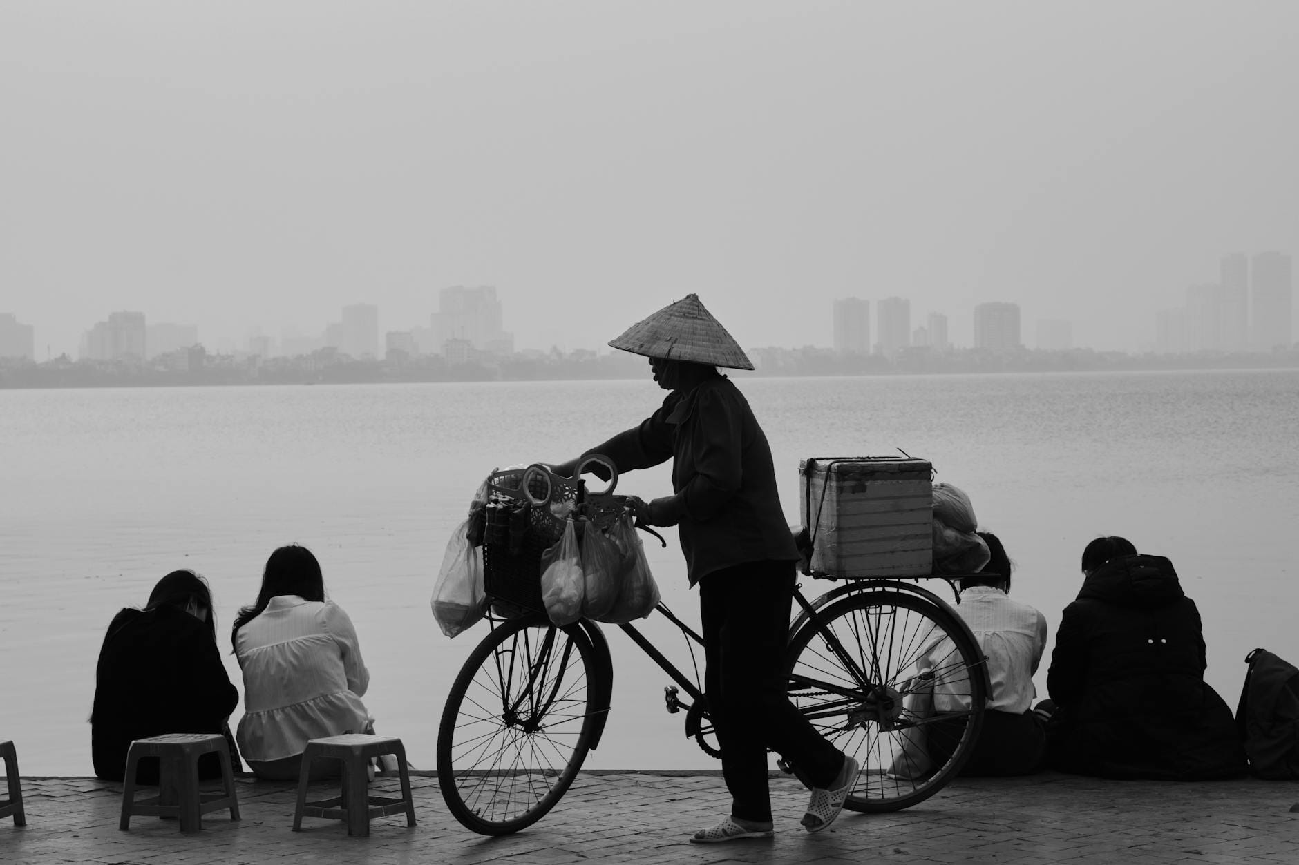 Sprzedawca uliczny z rowerem nad jeziorem w Hanoi