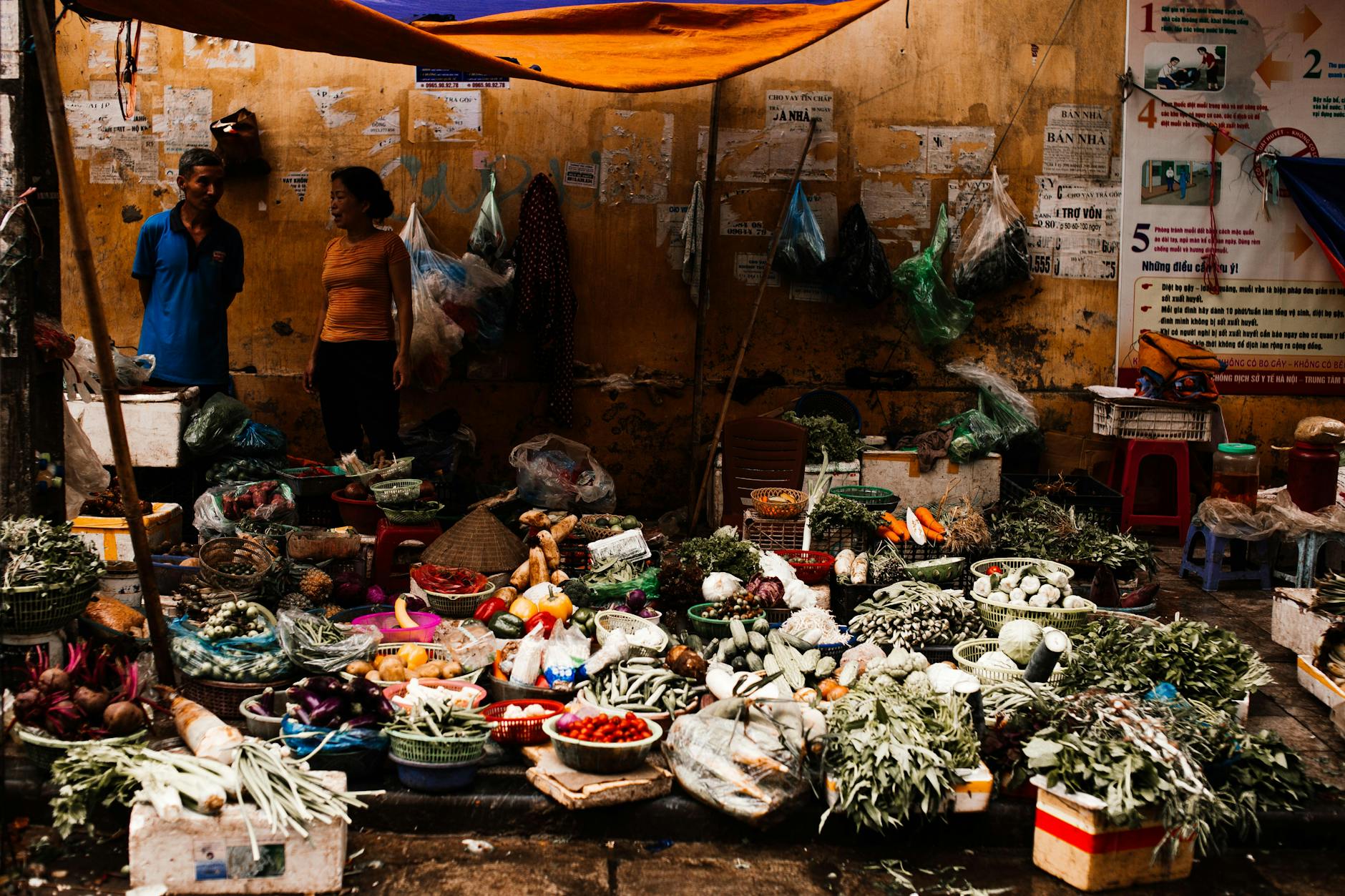 Stragan na wietnamskim targu z kolorowymi świeżymi warzywami