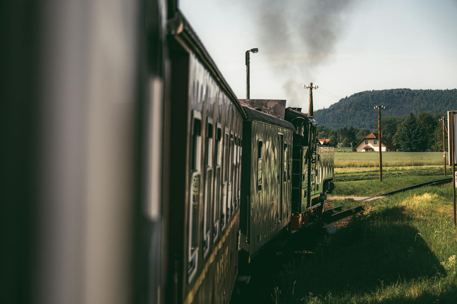 Zabytkowa lokomotywa parowa jedzie przez malowniczą wieś w Niemczech