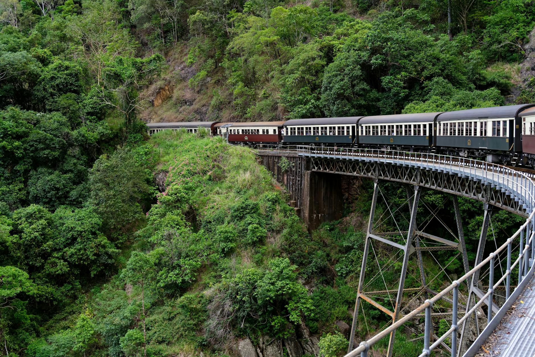 Zabytkowy pociąg jedzie przez zielony górski krajobraz