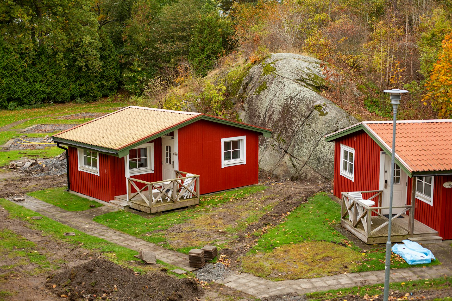 Czerwone domki nad jeziorem w jesiennym krajobrazie Smålandii