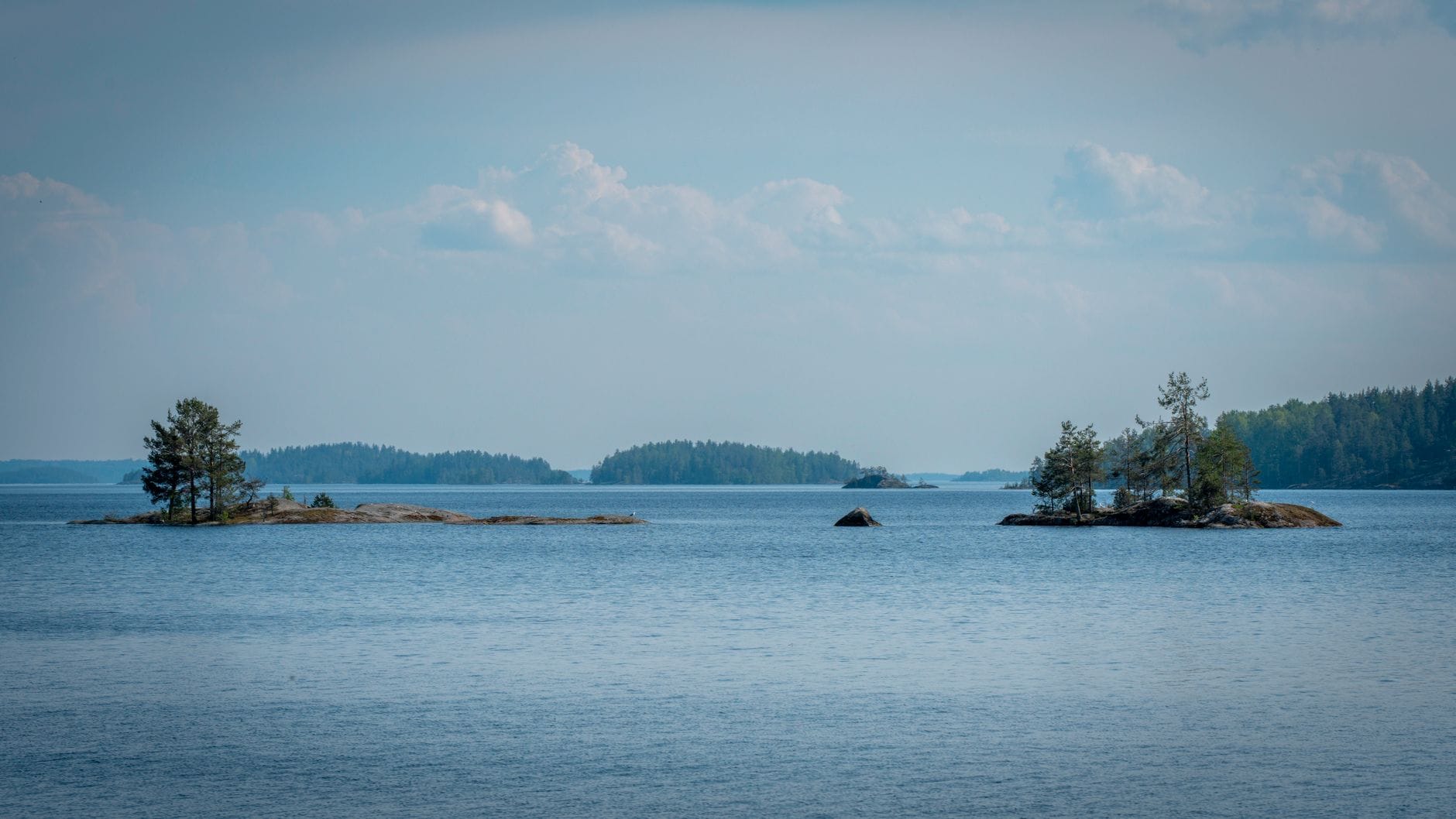 Wyspy na jeziorze Saimaa odbijające się w spokojnej tafli wody
